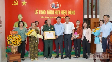 Bí thư Tỉnh ủy Đồng Tháp Lê Quốc Phong trao Huy hiệu 80 năm tuổi Đảng và tặng hoa chúc mừng đồng chí Thiếu tướng Lê Quang Viễn.