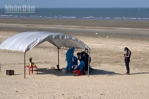 Lực lượng chức năng tiến hành khám nghiệm tử thi tại bờ biển xã Lộc Hà.