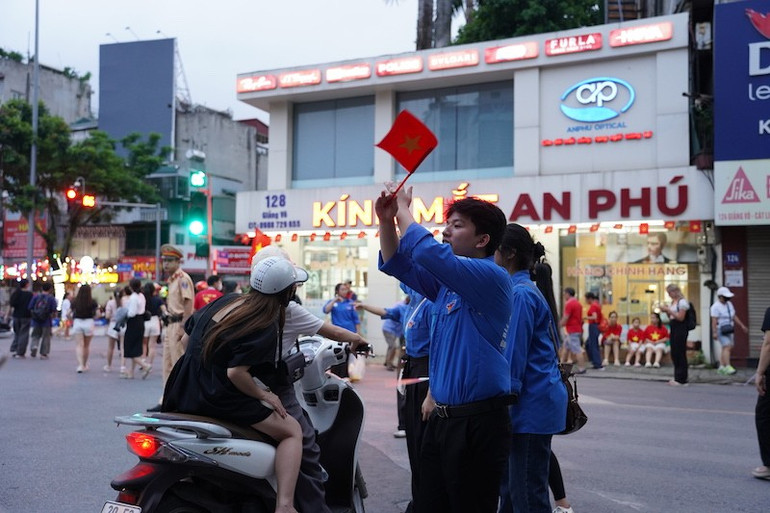 Lực lượng tình nguyện viên hỗ trợ cảnh sát giao thông điều phối việc đi lại trên phố Giảng Võ. (Ảnh: QUỲNH ANH) 2.jpg