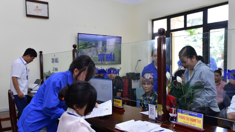 Lực lượng thanh niên tình nguyện hỗ trợ công chức giải quyết thủ tục hành chính cho người dân. (Ảnh: THANH THƯ) 9-7-thanh-nien-1-5473.jpg