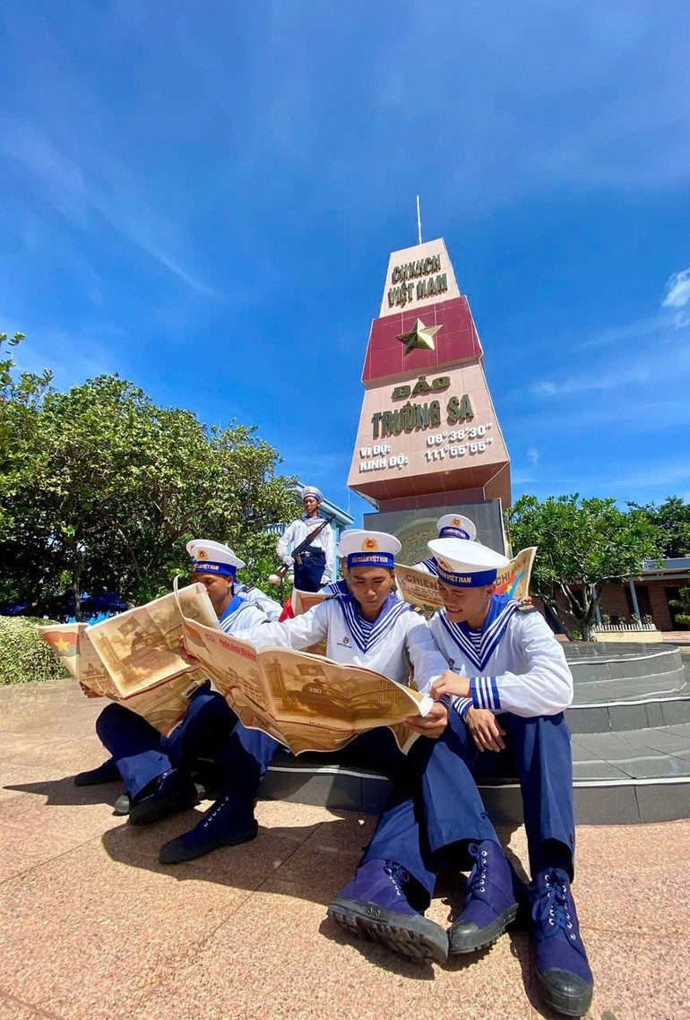 Các chiến sĩ làm nhiệm vụ trên đảo Trường Sa đọc phụ san đặc biệt của Báo Nhân Dân về Chiến dịch Hồ Chí Minh. (Ảnh: Báo Nhân Dân) 19-6-bao-2.jpg