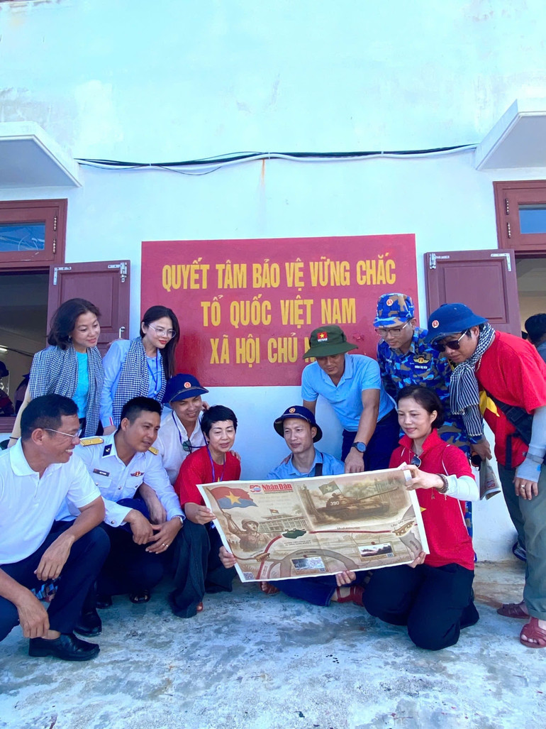 Các nhà báo cùng các cán bộ, chiến sĩ trên đảo Trường Sa cùng trải nghiệm phụ san của Báo Nhân Dân. (Ảnh: Báo Nhân Dân) 19-6-bao-1.jpg