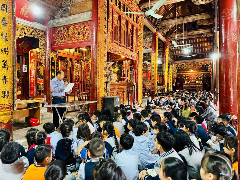 Học sinh Trường tiểu học Khu đô thị Sài Đồng nghe giới thiệu về đình Lệ Mật (phường Việt Hưng), một ngôi đình ngay gần khu dân cư các em sinh sống. (Ảnh: Giang Nam) 5-8-van-hoa-13.jpg