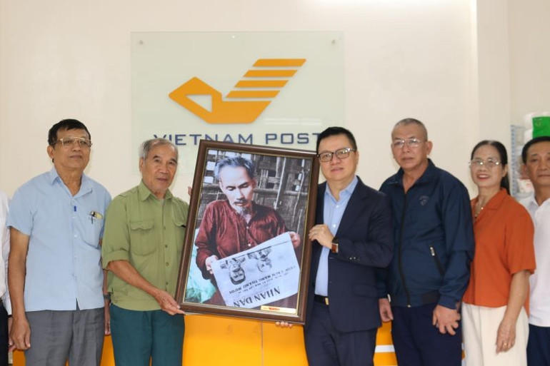 Kamrat Le Quoc Minh överlämnade en bild av farbror Ho som läser tidningen Nhan Dan till Bat Trang kommuns kulturpostkontor och lokalbefolkningen. 28-10-phu-truong-3.jpg