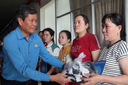 Phó Chủ tịch Tổng Liên đoàn Lao động Việt Nam Huỳnh Thanh Xuân động viên, trao quà hỗ trợ cho công nhân vùng lũ Đắk Lắk.