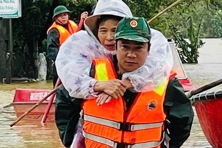 Lực lượng vũ trang dầm mình trong nước lũ giúp đỡ nhân dân.