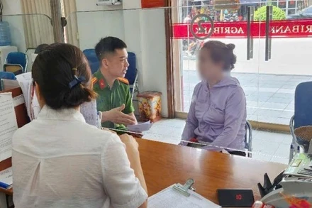 Cán bộ công an và nhân viên ngân hàng giải thích cho bà T. về thủ đoạn của các đối tượng lừa đảo. Ảnh: ANTĐ