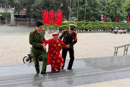 Cán bộ, chiến sĩ Công an phường Đống Đa hỗ trợ cử tri cao tuổi đến địa điểm bỏ phiếu.