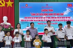 Lãnh đạo Ban Tuyên giáo và Dân vận Tỉnh ủy Khánh Hòa và đại diện lãnh đạo Hải đoàn 32, Bộ Tư lệnh Vùng Cảnh sát biển 3 tặng quà cho học sinh là con ngư dân xã Cà Ná. (Ảnh: NGUYỄN TRUNG)