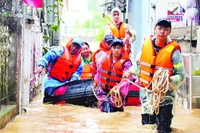 Lực lượng Cảnh sát phòng cháy, chữa cháy và cứu nạn, cứu hộ hỗ trợ người dân phường Thục Phán (Cao Bằng) di dời đến nơi an toàn. (Ảnh: TRÍ CAO)