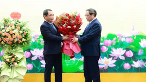 Thủ tướng Phạm Minh Chính tặng hoa chúc mừng quyền Bộ trưởng Nông nghiệp và Môi trường Trần Đức Thắng. (Ảnh: TRẦN HẢI)