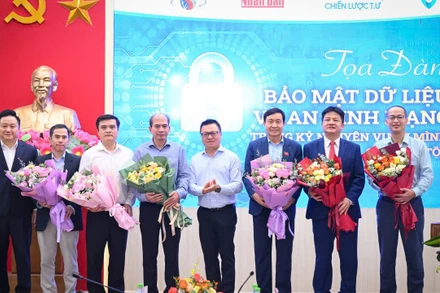 Tổng Biên tập Báo Nhân Dân Lê Quốc Minh và Phó Tổng Biên tập Báo Nhân Dân Phan Văn Hùng tặng hoa các diễn giả của buổi tọa đàm về bảo mật dữ liệu và an ninh mạng. (Ảnh: THÀNH ĐẠT)