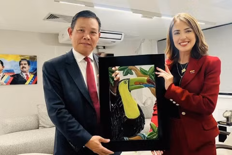Bộ trưởng Du lịch Venezuela Daniella Cabello trao quà kỷ niệm tặng Đại sứ Vũ Trung Mỹ. (Ảnh do Đại sứ quán Việt Nam tại Venezuela cung cấp)