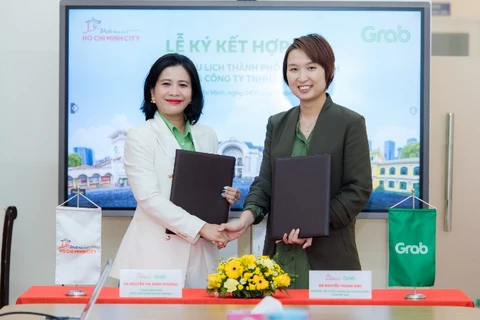 Bà Nguyễn Thị Minh Phương (trái), Chánh Văn phòng Sở Du lịch Thành phố Hồ Chí Minh và bà Nguyễn Thanh Anh, Giám đốc Tiếp thị và Thương mại Doanh nghiệp, Grab Việt Nam tại lễ ký kết.