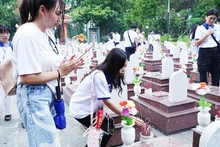 Thanh niên kiều bào thắp hương tưởng nhớ các anh hùng liệt sĩ tại Nghĩa trang Trường Sơn. Ảnh: NVNONN