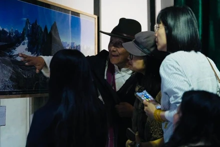 Nhiếp ảnh gia Sonam đang giới thiệu với khách tham quan về những bức ảnh về vùng núi tuyết Himalaya.