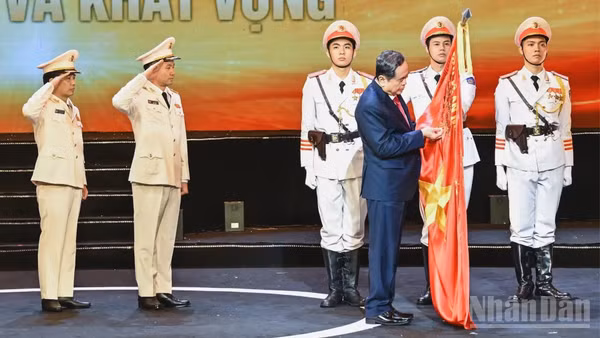 Chủ tịch Quốc hội Trần Thanh Mẫn gắn Huân chương Hồ Chí Minh lên lá cờ truyền thống của lực lượng Cảnh sát kinh tế. (Ảnh: DUY LINH)