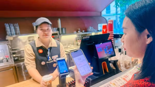Khách hàng quét mã VietQR Global thanh toán tại điểm bán hàng. (Ảnh: QUỲNH TRANG)