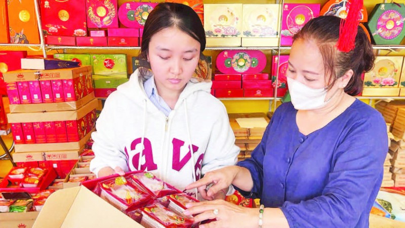 Mẹ con chị Bạch Thị Bích Phượng, chủ một cơ sở bán bánh trung thu trên đường Lê Thánh Tông, phường Buôn Ma Thuột chuẩn bị bánh bán cho khách hàng.