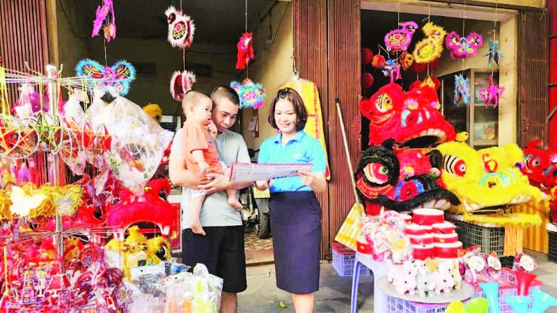Cán bộ BHXH cơ sở Phúc Yên tuyên truyền, vận động người dân tham gia bảo hiểm y tế.