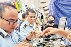 Cán bộ Quản lý thị trường kiểm tra hàng hóa tại Trung tâm Thương mại Saigon Square (Thành phố Hồ Chí Minh).