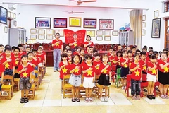 Cô và trò thực hiện nghi thức chào cờ trước khi vào chương trình xem phim về Quốc khánh 2/9.