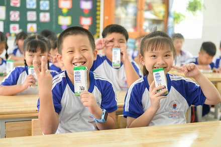 Các em học sinh trường Tiểu học Trang Tấn Khương, xã Long Thới, huyện Nhà Bè vui vẻ đón nhận những hộp sữa an toàn từ chương trình SHĐ.