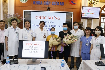 Các thầy thuốc tặng hoa chúc mừng chị Tâm đã khỏe mạnh và trở về với gia đình.