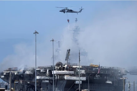 Trực thăng chữa cháy đang phun nước từ trên cao. (Ảnh: Reuters)