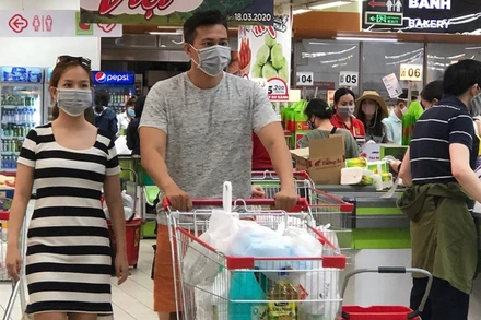 Người dân đeo khẩu trang khi đi mua sắm tại siêu thị vào tháng 3-2020. (Ảnh: T. Xuân)