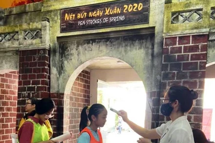 Đo thân nhiệt cho khách tham quan tại di tích Hoàng thành Thăng Long.