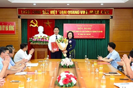 Lãnh đạo Thành ủy Hà Nội trao quyết định cho tân Bí thư Quận ủy Hà Đông. (Ảnh: BÁ HOẠT)