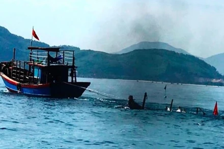 Lực lượng chức năng kéo phương tiện câu mực của ông Thà bị tàu cá đâm chìm trên biển vào bờ.