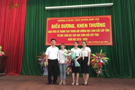 Lê Vân Anh trong vòng tay yêu thương của thầy, cô nhà trường. (Ảnh do BGH Trường THCS nội trú Hàm Yên cung cấp)