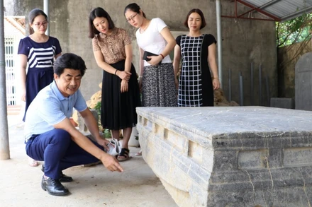 Cán bộ Bảo tàng Ninh Bình nghiên cứu họa tiết, hoa văn trên sập đá cổ, phát hiện ở xã Xích Thổ, huyện Nho Quan (Ninh Bình).