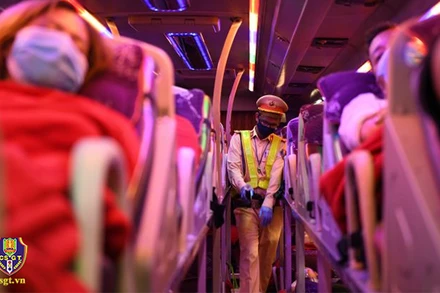 Chiến sĩ cảnh sát giao thông nhắc nhở hành khách trên xe thắt dây an toàn. (Ảnh: Cục CSGT)