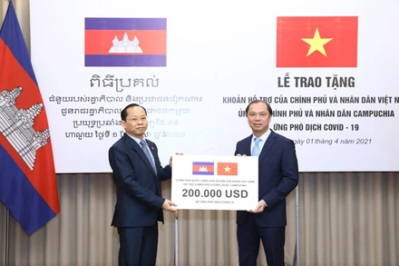 Thứ trưởng Ngoại giao Nguyễn Quốc Dũng trao tượng trưng cho Đại sứ Campuchia tại Việt Nam Chay Navuth khoản hỗ trợ 200.000 USD. (Ảnh: Bộ Ngoại giao Việt Nam)