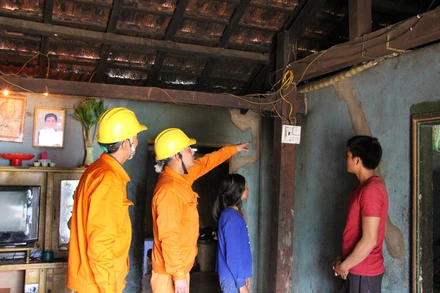 Công nhân Điện lực Ngọc Hồi (PC Kon Tum) sửa chữa, thay thế dây, bóng điện miễn phí cho các hộ nghèo tại vùng biên giới huyện Ngọc Hồi, tỉnh Kon Tum.