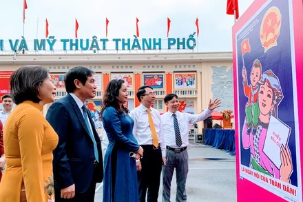 Các đại biểu xem tranh cổ động trưng bày tại triển lãm