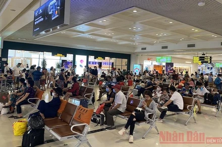 Ghi nhận tại khu vực hành khách chờ lên máy bay sau khi làm thủ tục chuyến bay (check in) ở Cảng hàng không quốc tế Nội Bài trưa 25-4, vẫn có những hành khách không đeo khẩu trang theo quy định. (Ảnh: HẢI CHÍNH)