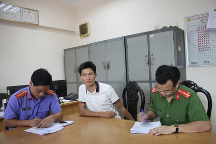 Đối tượng Vàng A Bông (giữa) tại cơ quan công an.