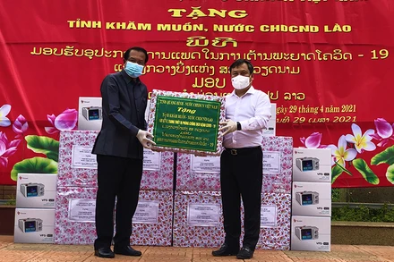 Bí thư Tỉnh ủy Quảng Bình Vũ Đại Thắng (áo trắng) trao tặng thiết bị phòng chống dịch cho lãnh đạo tỉnh Khăm Muộn.