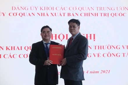 Đồng chí Huỳnh Tấn Việt (bên phải) trao Quyết định chuẩn y Bí thư Đảng ủy cơ quan NXB Chính trị quốc gia Sự thật cho đồng chí Phạm Minh Tuấn, Giám đốc, Tổng Biên tập NXB.