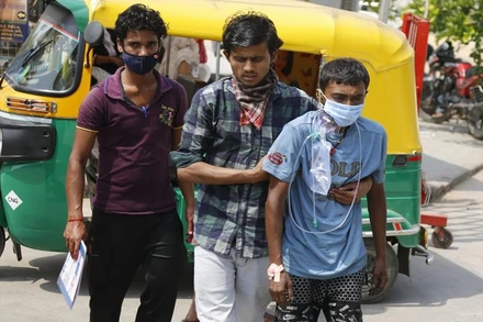 Người mắc Covid-19 được người thân đưa tới bệnh viện tại TP Ahmedabad, Ấn Độ, để điều trị. (Ảnh: AP)