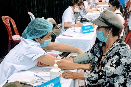 Các nhân viên y tế khám, tư vấn cho người dân trước khi tiêm vaccine phòng Covid-19.