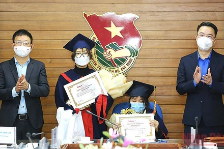 Đồng chí Nguyễn Tường Lâm, Bí thư Trung ương Đoàn (ngoài cùng bên phải) và ông Phùng Công Sưởng, Phó Tổng Biên tập Báo Tiền Phong trao học bổng “Nâng bước thủ khoa” năm 2021 tặng các nữ sinh Phí Thị Kim Oanh (ngồi ghế) và Nguyễn Hồng Minh.