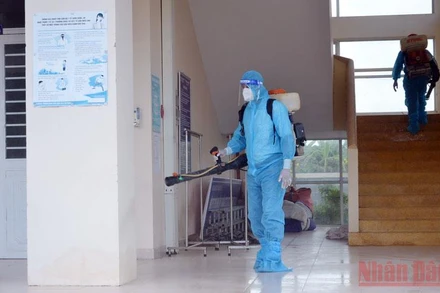 Nhân viên y tế phun hóa chất khử khuẩn trường học.