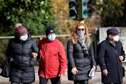 Người dân đeo khẩu trang đi bộ trên đường phố Rome, khi vùng Lazio ra quy định bắt buộc phải đeo khẩu trang ở tất cả các khu vực ngoài trời, Rome, Italia, ngày 23/12/2021. (Ảnh: Reuters)