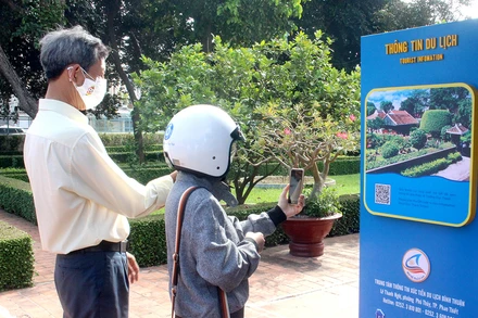Người dân trải nghiệm quét mã QR tại một điểm tham quan. 