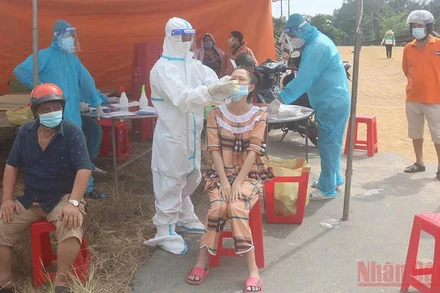 Nhân viên y tế xét nghiệm nhanh SARS-CoV-2 cho người dân. 